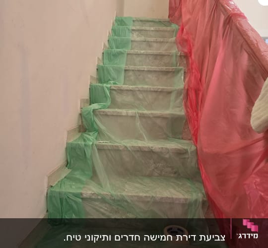 מדרגות מכוסות בניילון ירוק ואדום לשיפוץ